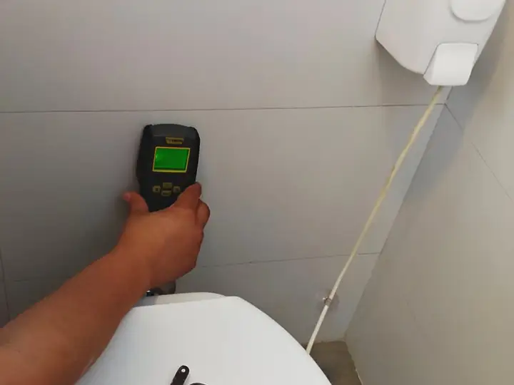 Medidor de umidade encostado em parede de azulejo