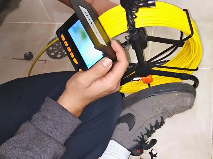 Técnico usando câmera de inspeção no banheiro de um apartamento